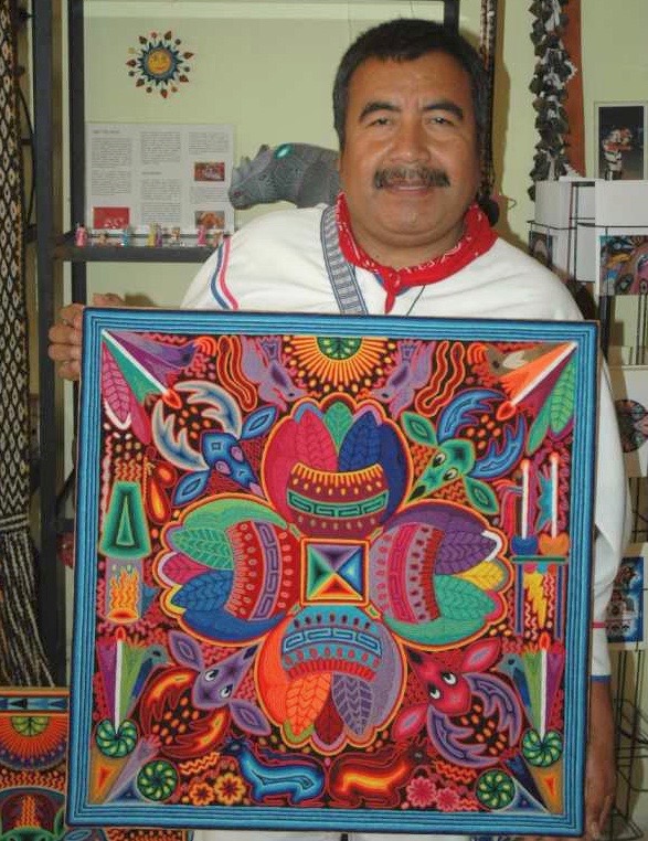 Santos Daniel Huichol artist holding his yarn painting