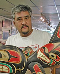 Lawrence Scow holding his Killer whale carving