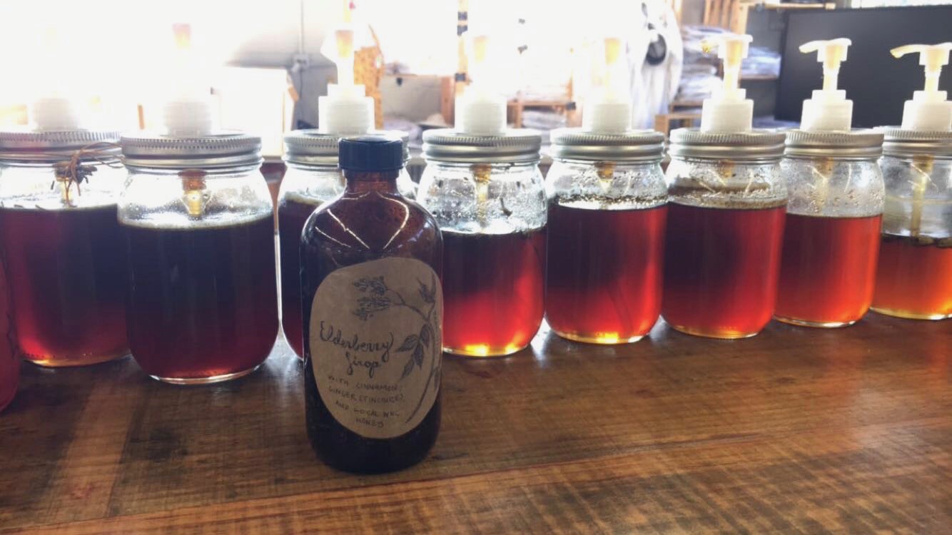 Kathleen's homemade elderberry syrup among the Wild Mountain Bees honeys.